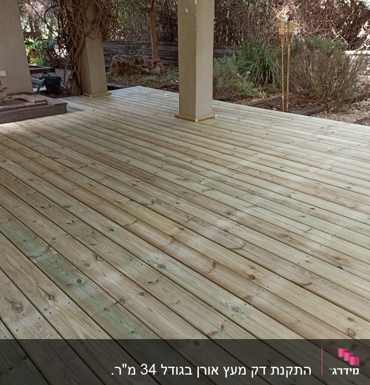 דק עץ חדש בגינה עם עמודים ותאורה